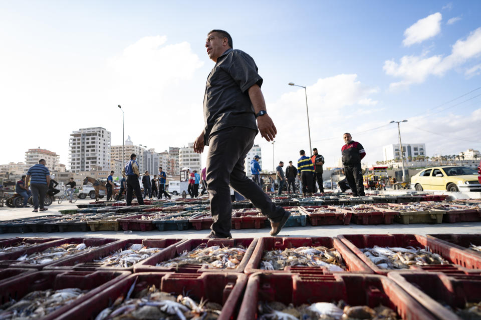 Lots of seafood are organized on the ground as buyers browse the day's catch at auction after a limited number of boats were allowed to return to the sea following a cease-fire reached after an 11-day war between Hamas and Israel, in Gaza City, Sunday, May 23, 2021. (AP Photo/John Minchillo)