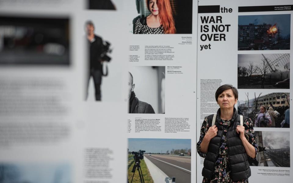 A woman reads from The War Is Not Over exhibition stands in Taras Shevchenko Park on June 23, 2022 in Kyiv, Ukraine - Alexey Furman/Getty Images