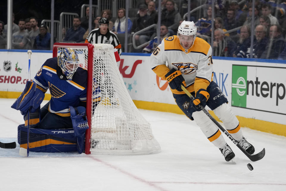 Nashville Predators' Cole Smith (36) controls the puck as St. Louis Blues goaltender Jordan Binnington defends during the first period of an NHL hockey game Monday, Dec. 12, 2022, in St. Louis. (AP Photo/Jeff Roberson)