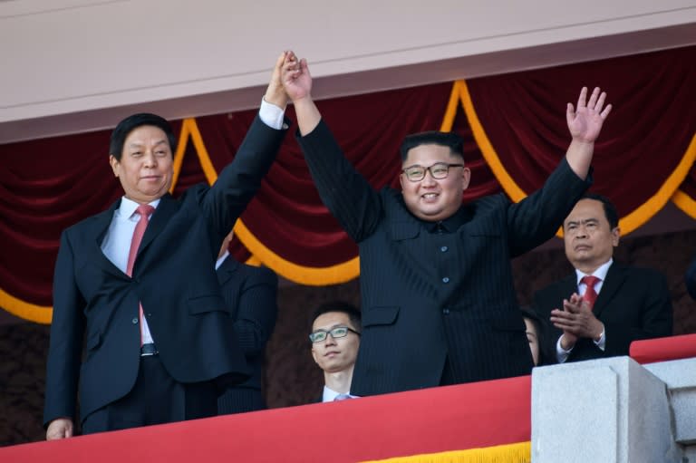 Politburo Standing Committee member Li Zhanshu (L) met North Korea's leader Kim Jong Un (R) during a military parade and mass rally to mark the 70th anniversary of the founding of North Korea