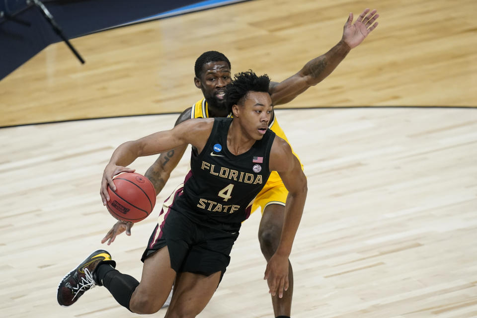 FILE - In this March 28, 2021, file photo, Florida State guard Scottie Barnes (4) drives past Michigan guard Chaundee Brown during the first half of a Sweet 16 game in the NCAA men's college basketball tournament in Indianapolis. The Seminoles freshman is one of the top forwards in the NBA draft with his versatility to play inside or out. (AP Photo/Darron Cummings, File)