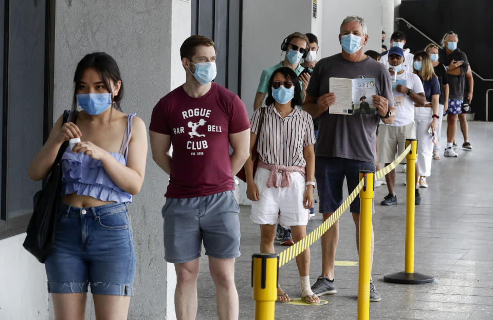 People wait in a line at a COVID-19 testing station on the northern beaches in Sydney, Australia, Monday, Dec. 21, 2020. Sydney's northern beaches are in a lockdown similar to the one imposed during the start of the COVID-19 pandemic in March as a cluster of cases in the area increased to more than 80. (AP Photo/Mark Baker)