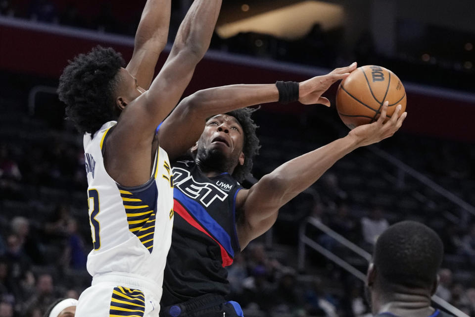 Detroit Pistons center James Wiseman (13) attempts a layup as Indiana Pacers forward Aaron Nesmith (23) defends during the first half of an NBA basketball game, Monday, March 13, 2023, in Detroit. (AP Photo/Carlos Osorio)