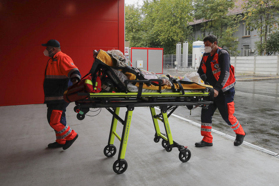 Paramedics bring an elderly patient to the emergency room, turned into a CODIV-19 unit due the high number of cases, at the Bagdasar-Arseni hospital in Bucharest, Romania, Tuesday, Oct. 12, 2021. Romania reported on Tuesday nearly 17,000 new COVID-19 infections and 442 deaths, the highest number of coronavirus infections and deaths in a day since the pandemic started, as the nation's health care system struggles to cope with an acute surge of new cases.(AP Photo/Andreea Alexandru)