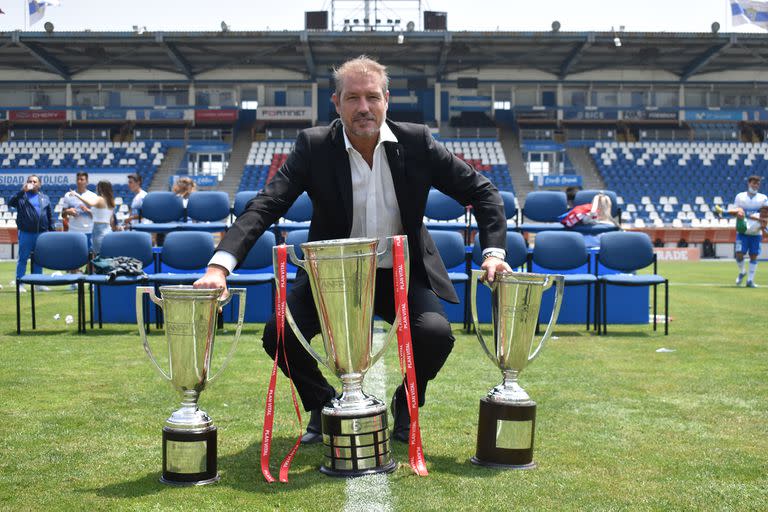 El Tati, con las copas de los últimos tres campeonatos ganados, en el estadio de la Universidad Católica