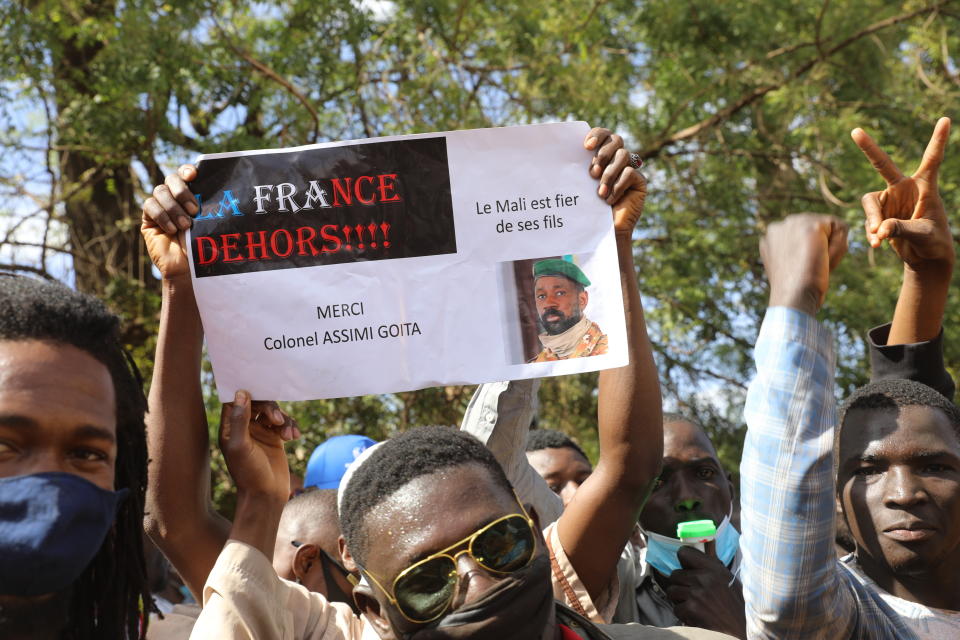 FILE - People join a government-sponsored rally in Mali's capital Bamako on Jan. 14, 2021, to protest new regional economic sanctions and growing pressure from former coloniser France, after Mali's military ruler pushed back promised elections by four years. Sign reads: "France Out" , "Mali is proud of its sons" and "Thank you Colonel Assimi Goita." (AP Photo/Harandane Dicko, File)