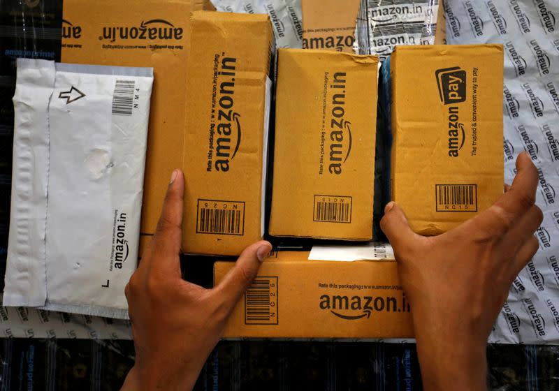 FILE PHOTO: A worker sorts delivery packages in a van outside an Amazon facility in Ahmedabad