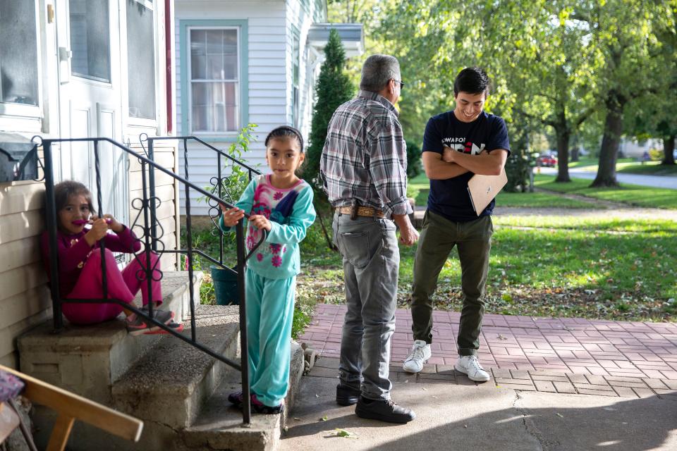 Camilo Haller, a field organizer for Joe Biden's campaign for president, talks to Ramon Medina-Rios, of Storm Lake, while knocking doors on Thursday afternoon, Oct. 17, 2019, in Storm Lake.  
