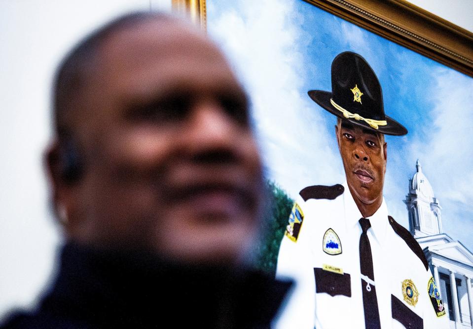 Lowndes County Sheriff Christopher West, foreground, reminisces about slain Lowndes County Sheriff Big John Williams, a year after Williams' death, as he stands near a portrait of Williams at the county courthouse in Hayneville, Alabama, on Nov. 12, 2020.