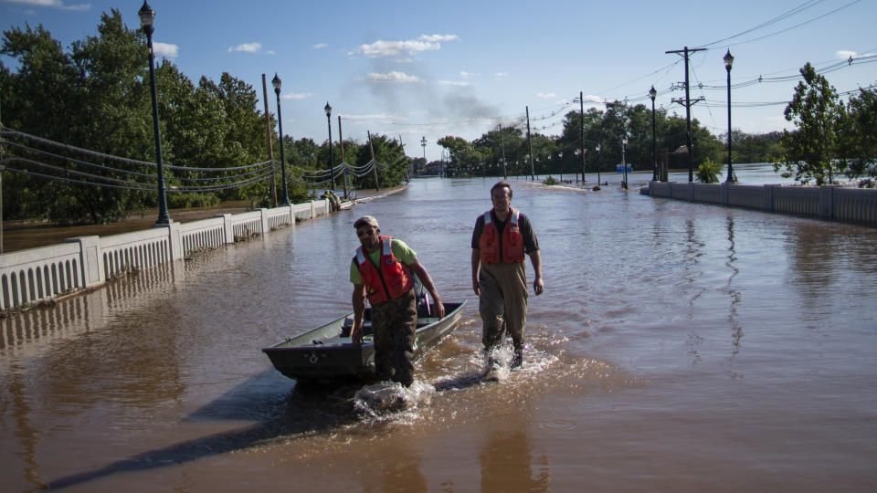 United States Geological Survey workers push a boat as they look for residents on a flooded street along the Raritan River in Somerville, N.J.., Thursday, Sept. 2, 2021. A stunned U.S. East Coast faced a rising death toll, surging rivers, tornado damage and continuing calls for rescue Thursday after the remnants of Hurricane Ida walloped the region with record-breaking rain. (AP Photo/Eduardo Munoz Alvarez)