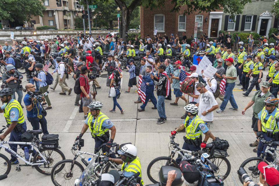 White nationalists, led by Jason Kessler, center, wearing a suit and carrying a flag, march to Lafayette Square during the "Unite the Right 2" rally in Washington, Sunday, Aug. 12, 2018. (Craig Hudson/Charleston Gazette-Mail via AP)