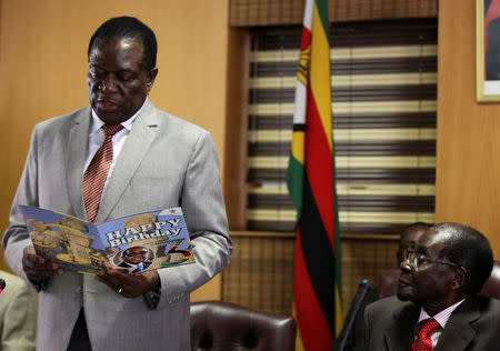 Zimbabwe's President Robert Mugabe looks on as his deputy Emmerson Mnangagwa reads a card during Mugabe's 93rd birthday celebrations in Harare, Zimbabwe, February 21, 2017. REUTERS/Philimon Bulawayo