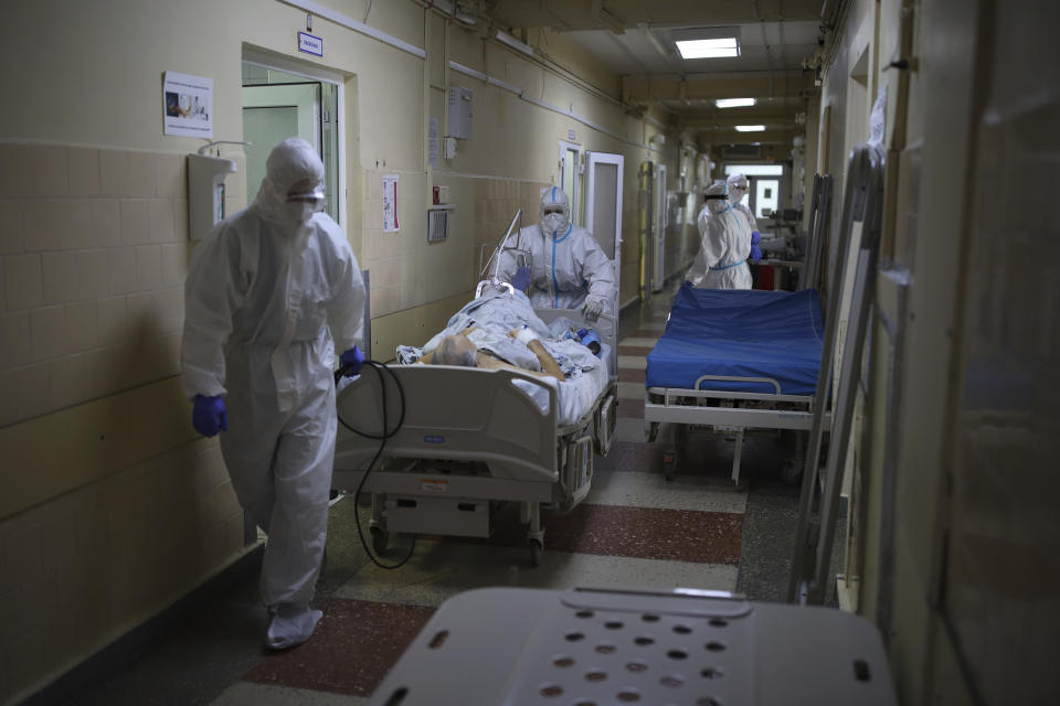 Medical staff members transfer a patient with COVID-19 at an ICU of a hospital in Krasnodar, southern Russia, Thursday, Jan. 27, 2022. Russia has confirmed 11,404,617 cases of coronavirus and 328,770 deaths, according to the national coronavirus information center. Russia's total excess fatality count since the start of the coronavirus pandemic is at least 929,000. Under half the population is fully vaccinated. (AP Photo/Vitaliy Timkiv)