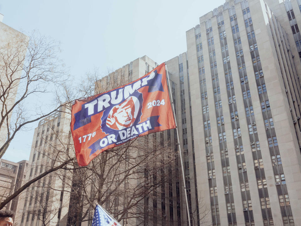 A supporter of former President Donald Trump waves a flag during a rally outside criminal court in New York City on April 4, 2023.<span class="copyright">Ismail Ferdous—Bloomberg/Getty Images</span>