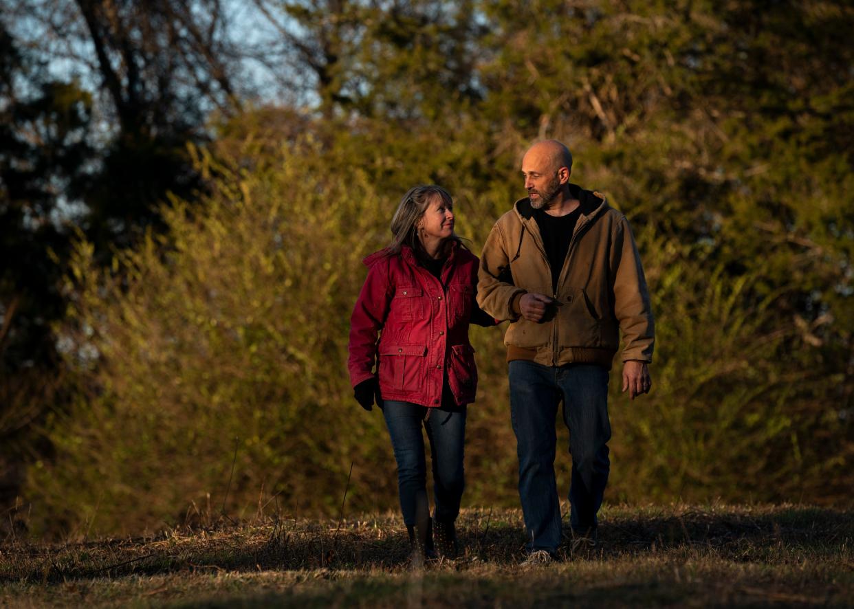 Julie and Matthew Hopkins head back to their four-wheeler after a portrait session with their cows on their Lynnville, Tenn., homestead Wednesday, Jan. 10, 2024. The couple relocated to Giles County, the next county over from their previous home in Marshall County, in order to get a fresh start after the couple's previous herd of about 50 cattle was unlawfully seized by the Marshall County Sheriff's Office. They were awarded $485,000 at trial.