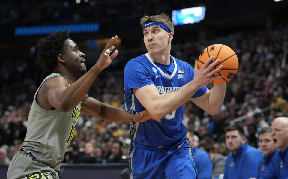 Creighton guard Baylor Scheierman, right, looks to pass the ball as Baylor guard Adam Flagler defends during the second half of a second-round college basketball game in the men's NCAA Tournament Sunday, March 19, 2023, in Denver. (AP Photo/David Zalubowski)