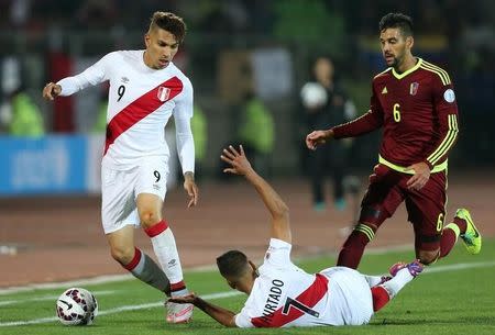 Peru's Christopher Hurtado falls as he and Paolo Guerrero are followed by Venezuela's Gabriel Cichero during their first round Copa America 2015 soccer match at Estadio Elias Figueroa Brander in Valparaiso, Chile, June 18, 2015. REUTERS/Rodrigo Garrido