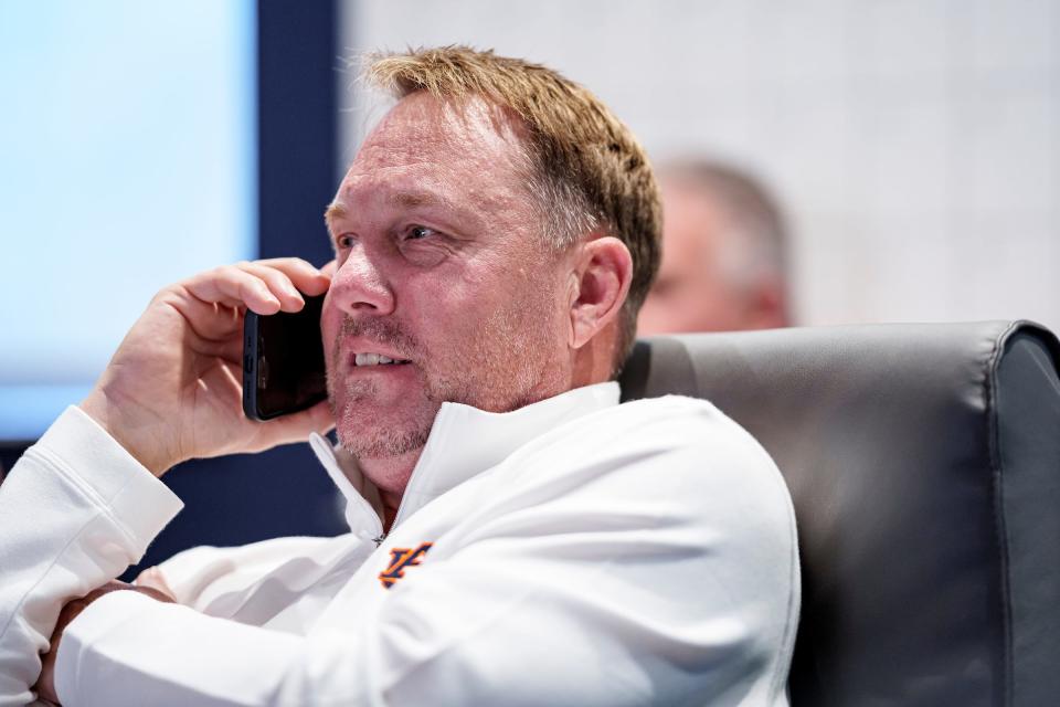 Auburn football coach Hugh Freeze congratulates a signee on the phone during early National Signing Day at the Woltosz Football Performance Center on Dec. 20, 2023.