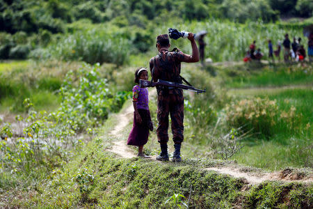 A member of Border Guard Bangladesh (BGB) tells a Rohingya girl not to come on Bangladesh side, in Cox’s Bazar, Bangladesh, August 27, 2017. REUTERS/Mohammad Ponir Hossain