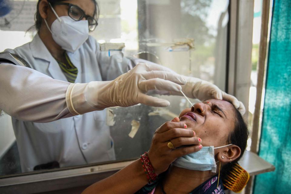 A health worker collects a nasal swab sample from a woman during a Covid-19 coronavirus screening held in Amritsar (AFP via Getty Images)