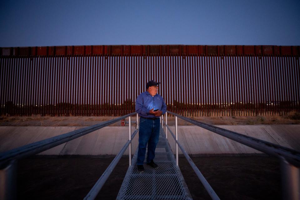 Robert Rios, water master for the El Paso County Water Improvement District No. 1 checks the water levels in a canal next to the border wall during a sunrise in July of 2023.