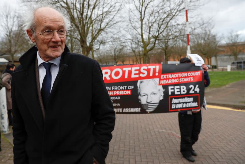 Un manifestante sostiene un cartel junto al padre de Assange, John Shipton, mientras abandona la prisión de Belmarsh después de visitar a Julian Assange, en Londres, Reino Unido