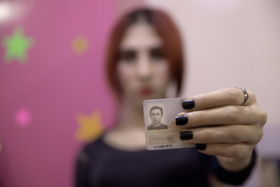 In this Oct. 28, 2019 photo, transgender woman Malak el-Kashif shows her identification card that has not been changed after her transition, in Cairo, Egypt. She has been ostracized by her family and scorned by some who accuse her of tampering with God's creation. She has been attacked by others scandalized by her activism for LGBTQ rights. Legally, she still holds a male's identity card. (AP Photo/Nariman El-Mofty)