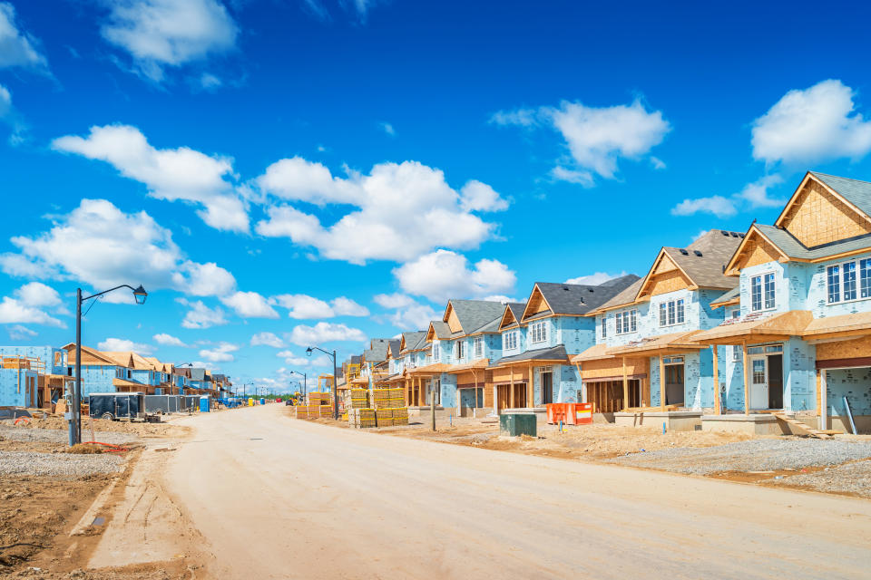 Houses are under construction in a new residential district on a sunny day.