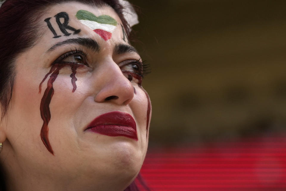 FILE - An Iranian woman, name not given, breaks into tears after a member of security seized her flag reading "Woman Life Freedom" before the start of the World Cup group B soccer match between Wales and Iran, at the Ahmad Bin Ali Stadium in Al Rayyan, Qatar, Friday, Nov. 25, 2022. (AP Photo/Alessandra Tarantino, File)