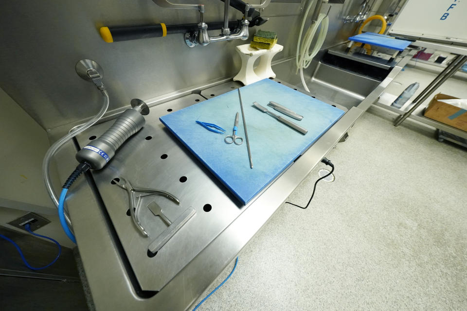 Rib sheers, a new autopsy saw, a set of forceps and tweezers are arranged in one of the four autopsy bays at the Mississippi Crime Laboratory in Pearl, Miss., Aug. 26, 2021. (AP Photo/Rogelio V. Solis)