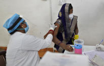 A woman receives the AstraZeneca vaccine for COVID-19 at a hospital in Prayagraj, India. Saturday, May 1, 2021. In hopes of taming a monstrous spike in COVID-19 infections, India opened vaccinations to all adults Saturday, launching a huge inoculation effort that was sure to tax the limits of the federal government, the country's vaccine factories and the patience of its 1.4 billion people. (AP Photo/Rajesh Kumar Singh)