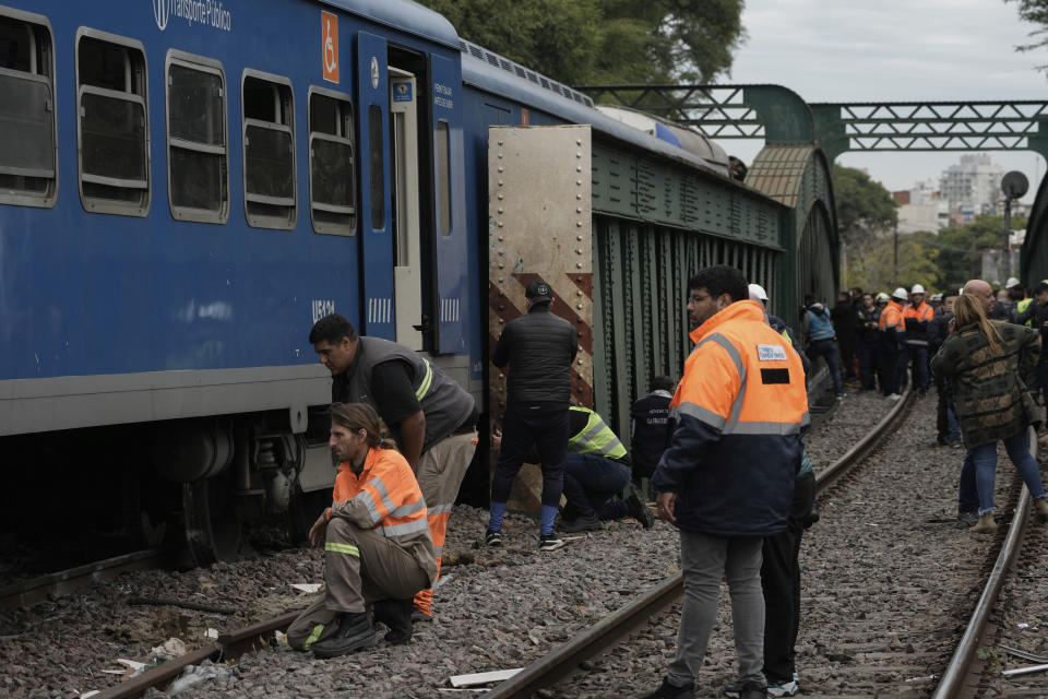 Railway workers inspect a passenger train after it collided with another in Buenos Aires, Argentina, Friday, May 10, 2024. (AP Photo/Rodrigo Abd)