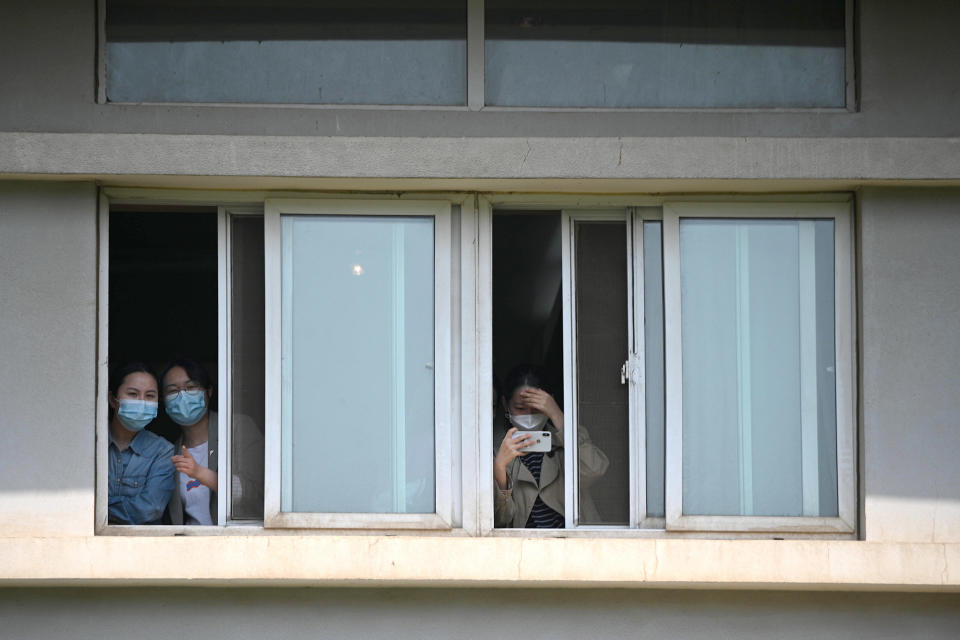 Varias personas con mascarilla se asoman a la ventana en el Hospital Jinyintan de Wuhan, en China, el 9 de abril de 2020 (AFP | Noel Celis)