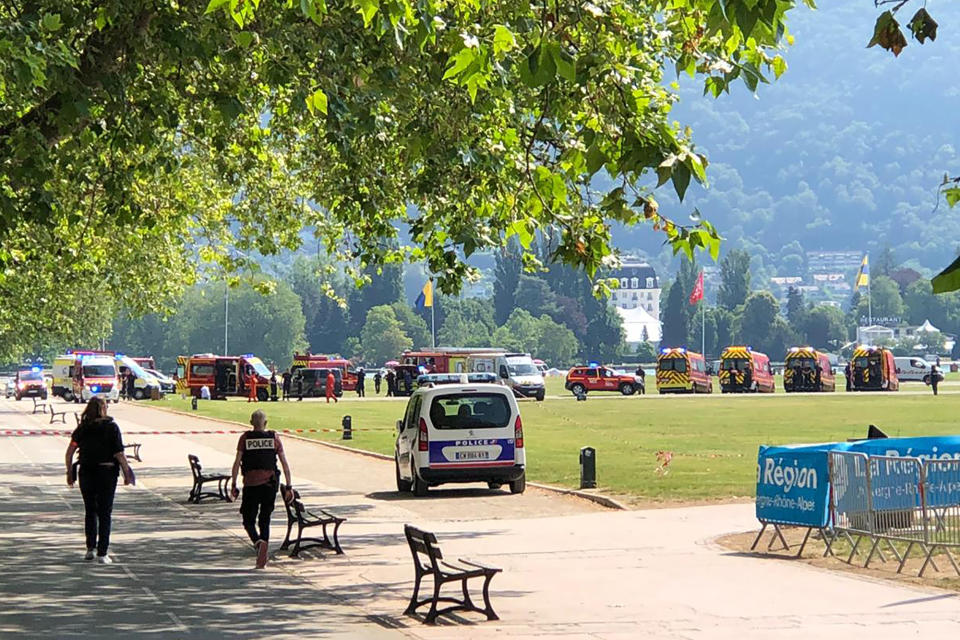 Police officers and rescuers walk at the scene after a knife attack in a park of Annecy, French Alps, Thursday, June 8, 2023. An attacker with a knife stabbed several young children and at least one adult, leaving some with life-threatening injuries, in a town in the Alps on Thursday before he was arrested, authorities said. (Florent Pecchio/L'Essor Savoyard via AP)