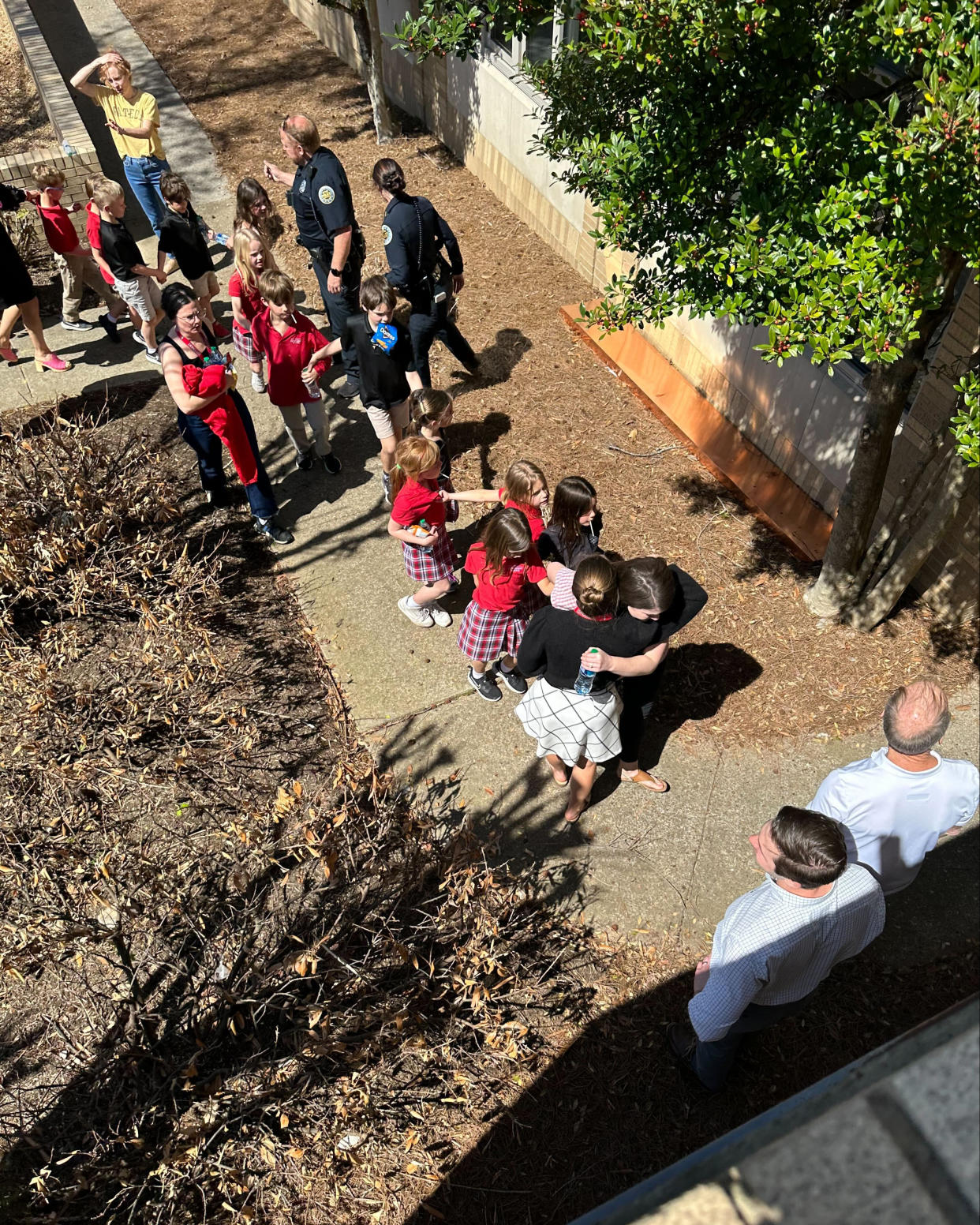 Children from The Covenant School, a private Christian school in Nashville, Tenn., hold hands as they are taken to a reunification site at the Woodmont Baptist Church after a shooting at their school, on Monday, March, 27, 2023. (George Uribe via AP)