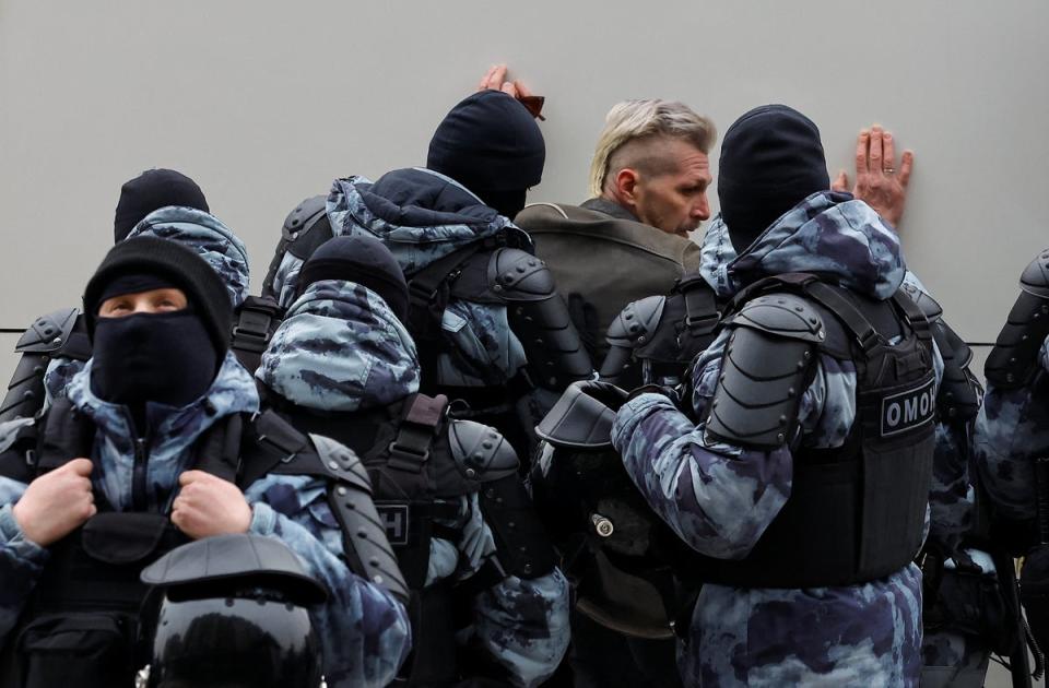 Police detain a person near the Borisovskoye cemetery (Reuters)