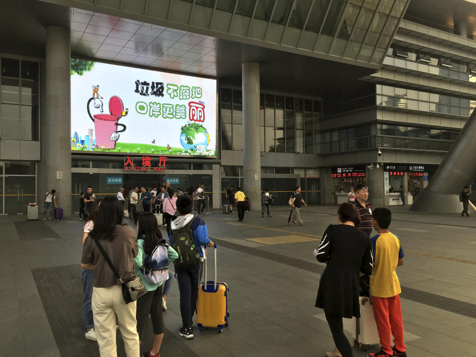 In this Thursday, Nov. 14, 2019 photo, travelers walk outside the arrival hall at the Shenzhen Bay Port in Shenzhen in southern China's Guangdong Province. Since anti-government demonstrators in Hong Kong began barricading university campuses earlier this week, hundreds of mainland Chinese students have retreated to neighboring Shenzhen, where the ruling Communist Party's Youth League has promised them a "warm home." (AP Photo/Yanan Wang)