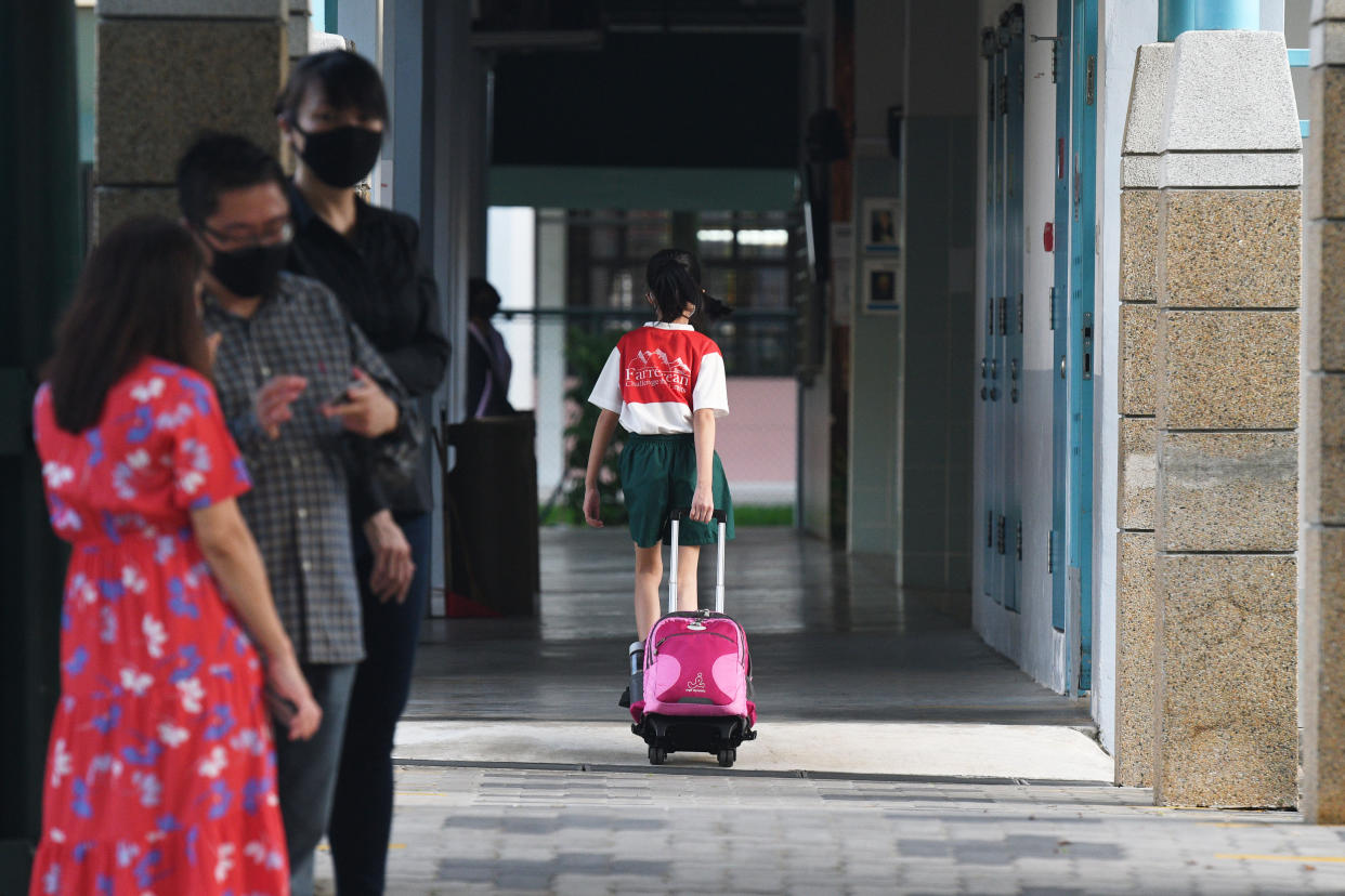 A primary school student pulling a school bag arrives at school in Singapore.