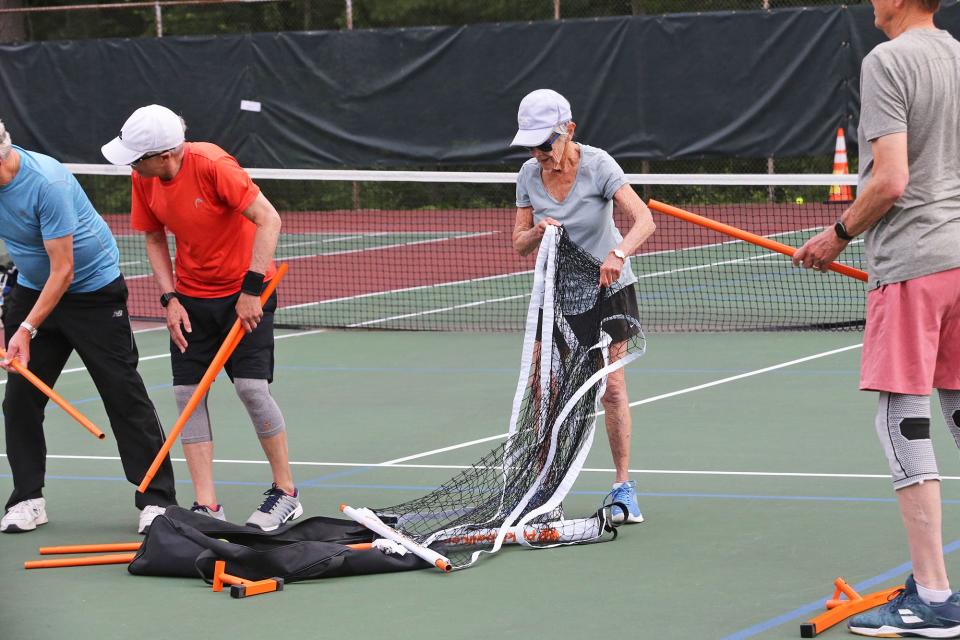 Louise Hirshberg, 93, sets up a pickleball net with other players on the courts at Exeter Recreation Park July 21, 2023.