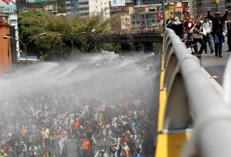 Police use a water cannon to disperse demonstrators during an opposition rally in Caracas, Venezuela, April 6, 2017. REUTERS/Christian Veron