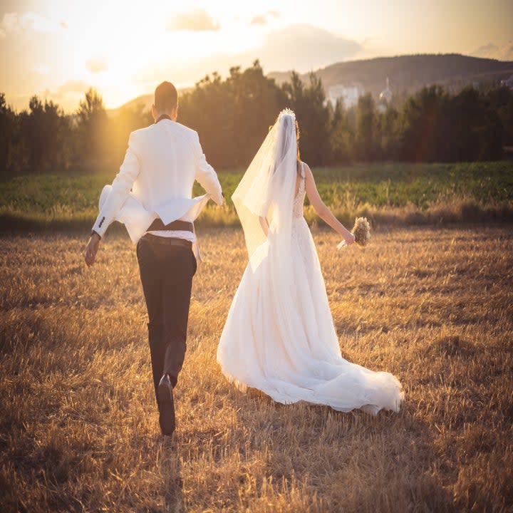 a couple holding hands and running on their wedding day