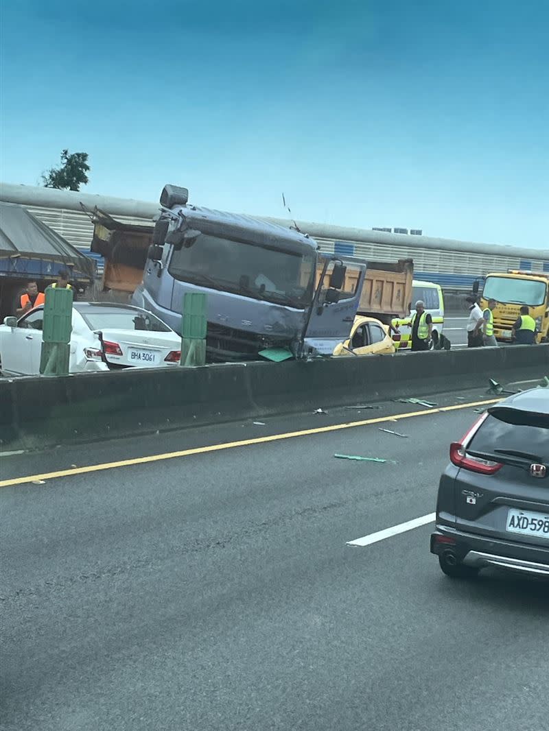 計程車被卡在砂石車中間，嚴重變形。（圖／翻攝自記者爆料網）