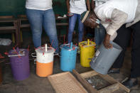 An electoral worker uses a counting board to tally marbles from a polling station during Gambia's presidential elections in Serrekunda, Gambia, Saturday, Dec. 4, 2021. Gambians vote in a historic election, one that for the first time will not have former dictator Yahya Jammeh appearing on the ballot. (AP Photo/Leo Correa)