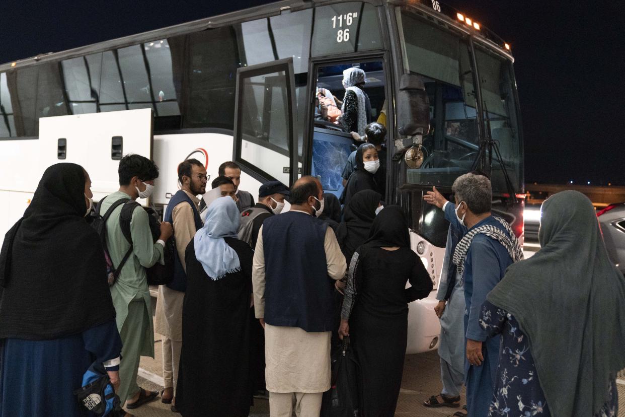 Families evacuated from Kabul, Afghanistan, are loaded into a buses after they arrived at Washington Dulles International Airport, in Chantilly, Va., on Saturday, Aug. 21, 2021. (Jose Luis Magana/AP)