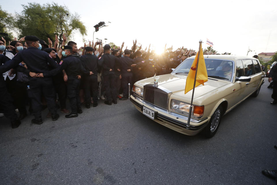 A vehicle with members of the Thai royal family onboard passes through a road where anti-government protesters gathered outside the Government House on Wednesday, Oct. 14, 2020 in Bangkok, Thailand. (AP Photo)