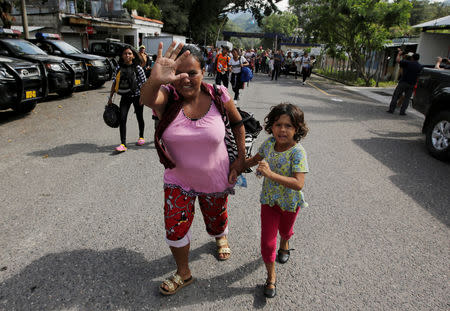 Honduran migrants, part of a caravan trying to reach the U.S., react after crossing the border between Honduras and Guatemala, in Agua Caliente, Guatemala October 15, 2018. REUTERS/Jorge Cabrera