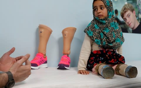 Maya Meri waits to be fitted with her new legs  - Credit: OSMAN ORSAL/ REUTERS