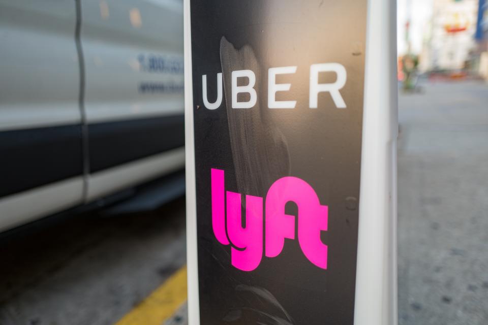 A sign marks a location where Uber or Lyft pickups are available in downtown Los Angeles, California. (Photo by Smith Collection/Gado/Getty Images)