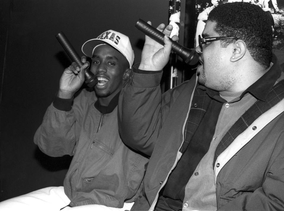 sean “puffy” combs and heavy d sing into microphones they hold