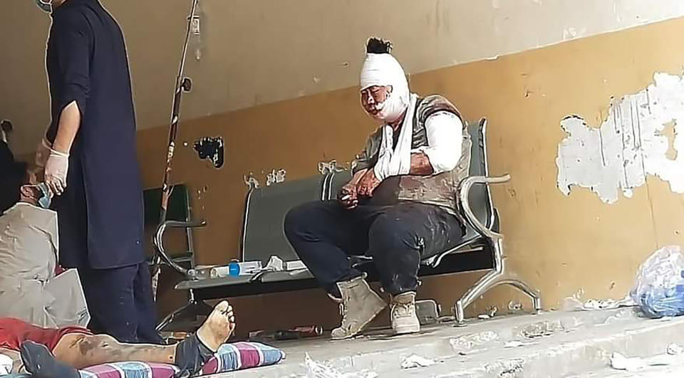 A Chinese national, who was injured in the bus accident, sits on a bench after receiving initial treatment at a hospital in Kohistan Kohistan district of Pakistan's Khyber Pakhtunkhwa province, Wednesday, July 14, 2021. A bus carrying Chinese and Pakistani construction workers on a slippery mountainous road in northwest Pakistan fell into a ravine Wednesday, killing a dozen of people, including Chinese nationals, and dozens were injured, a government official said. (AP Photo)